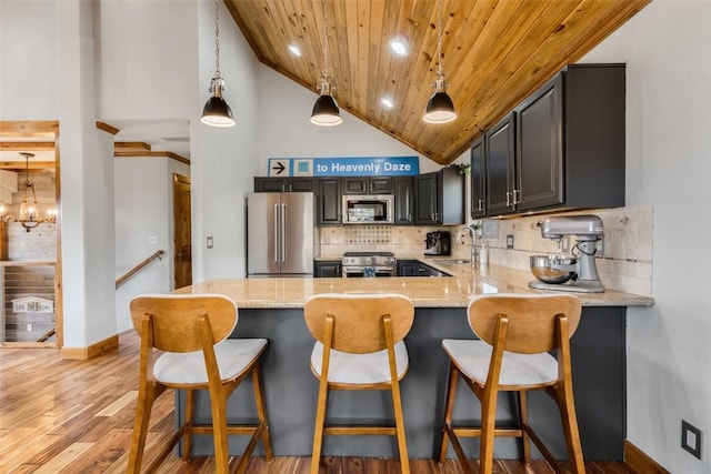 57415 Clara Way, Clark, CO 80428 - kitchen featuring high end appliances, a sink, high vaulted ceiling, wooden ceiling, and a peninsula