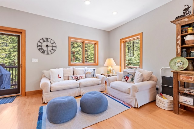 living area with light wood-style flooring, baseboards, and recessed lighting