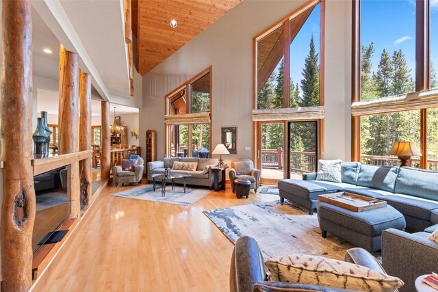 living area featuring wood finished floors, a towering ceiling, and recessed lighting