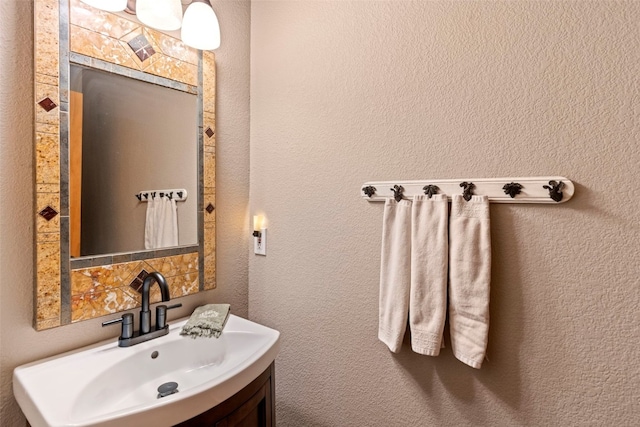bathroom with a textured wall and vanity