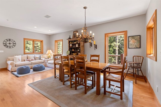 dining room featuring light wood-style flooring, baseboards, and a healthy amount of sunlight