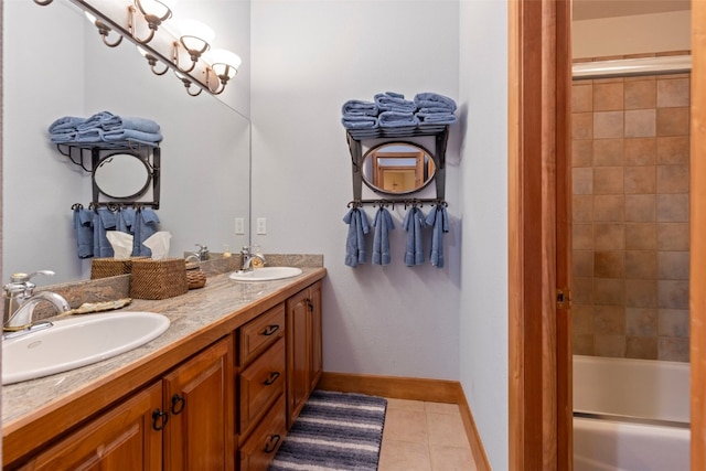 bathroom featuring baseboards, tile patterned floors, a sink, and double vanity