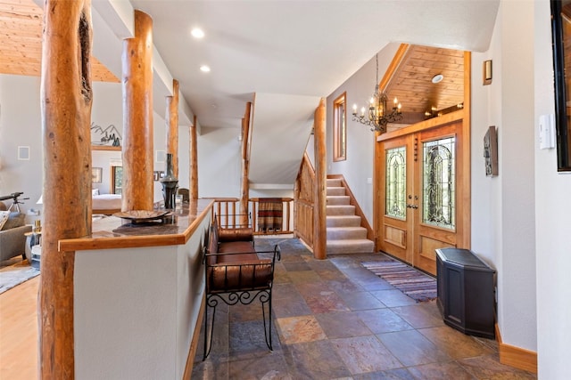 entryway featuring baseboards, recessed lighting, a chandelier, stone finish flooring, and stairs