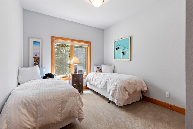 bedroom with light colored carpet and baseboards