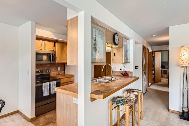 14 Crystal Cv Unit C14, Dillon, CO 80435 - kitchen featuring stainless steel microwave, range with electric cooktop, a breakfast bar, washer / clothes dryer, and light brown cabinetry