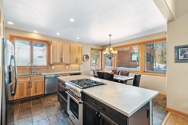 kitchen featuring stainless steel appliances, light countertops, a sink, and stone finish flooring