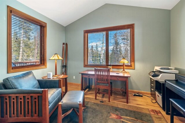 home office featuring vaulted ceiling, baseboards, and wood finished floors
