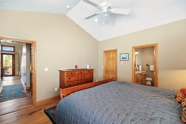 bedroom with baseboards, a ceiling fan, wood finished floors, high vaulted ceiling, and connected bathroom
