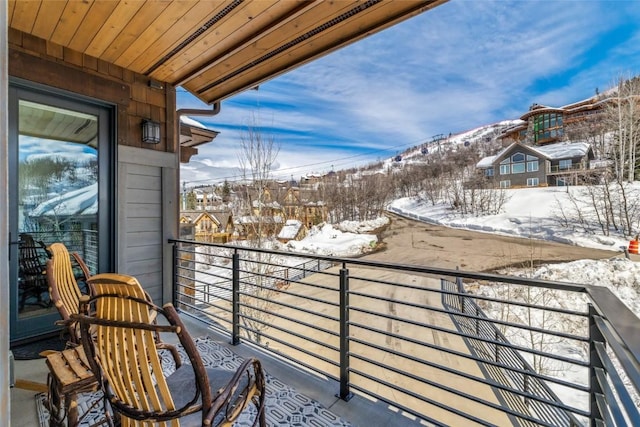 view of snow covered back of property