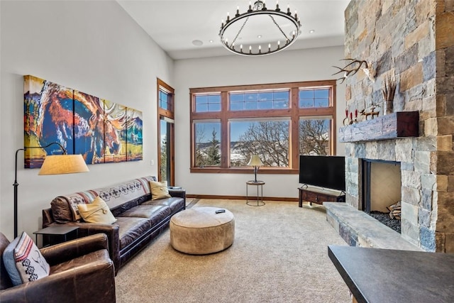 living room with a fireplace, a towering ceiling, baseboards, carpet, and an inviting chandelier