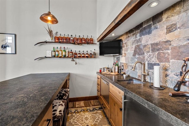 bar with baseboards, dark wood-type flooring, hanging light fixtures, a sink, and indoor wet bar