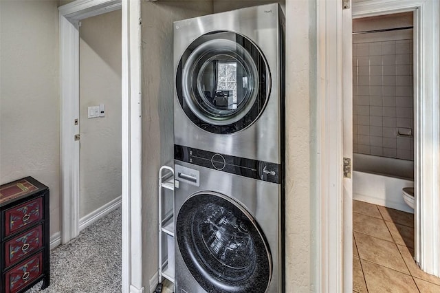 856 Kingdom Dr Unit 856, Breckenridge, CO 80424 - laundry area with stacked washer / dryer, a textured wall, tile patterned flooring, and baseboards
