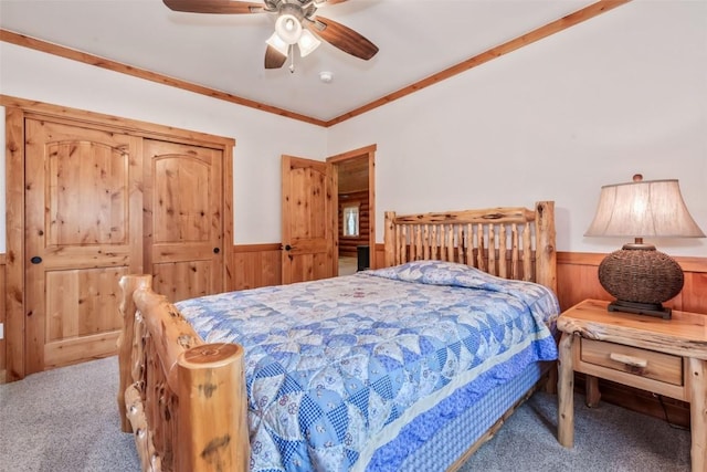 126 E 1st St, Oak Creek, CO 80467 - carpeted bedroom featuring a wainscoted wall, wood walls, a ceiling fan, and ornamental molding