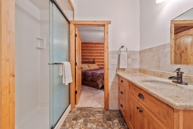 126 E 1st St, Oak Creek, CO 80467 - bathroom with vanity, a stall shower, ensuite bathroom, stone finish flooring, and log walls