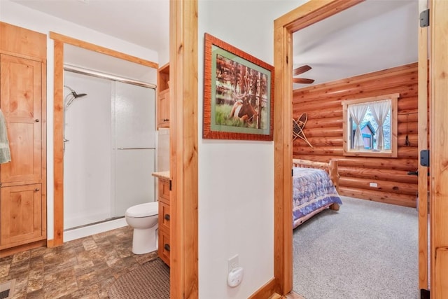 126 E 1st St, Oak Creek, CO 80467 - bathroom with log walls, a shower stall, toilet, a ceiling fan, and vanity