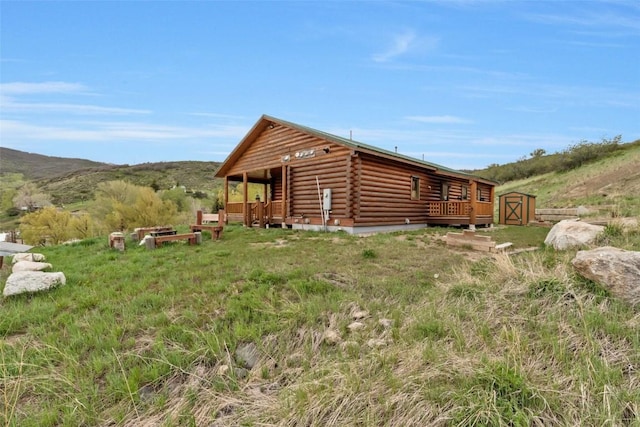 126 E 1st St, Oak Creek, CO 80467 - view of side of home with log siding, covered porch, and a mountain view