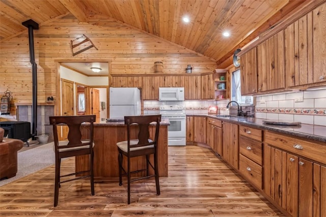 126 E 1st St, Oak Creek, CO 80467 - kitchen featuring white appliances, a sink, light wood-style flooring, a breakfast bar area, and open shelves