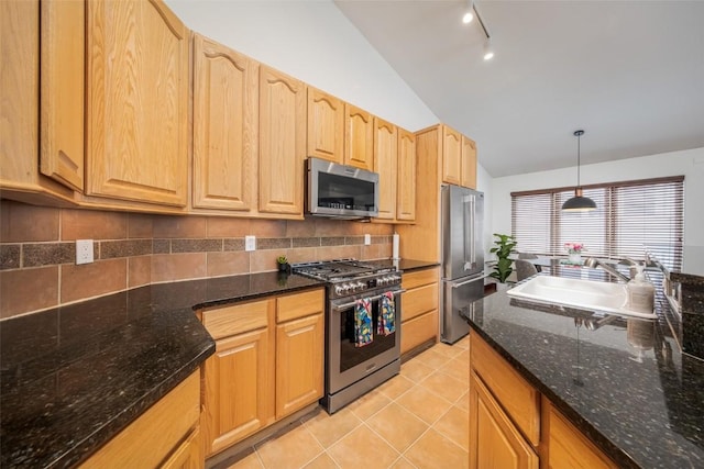kitchen featuring stainless steel appliances, vaulted ceiling, light tile patterned floors, a sink, and tasteful backsplash