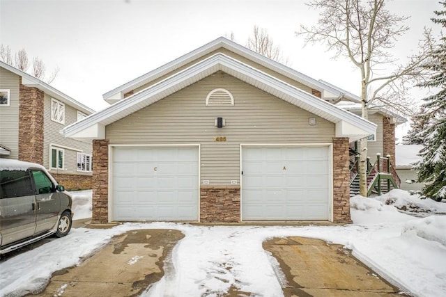 snow covered garage with a detached garage