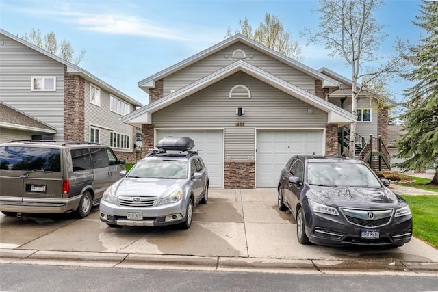 1485 Mustang Run Unit A, Steamboat Springs, CO 80487 - traditional-style house featuring concrete driveway, stone siding, and a garage