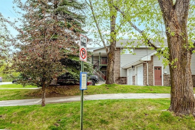 1485 Mustang Run Unit A, Steamboat Springs, CO 80487 - townhome / multi-family property with stairway, a front lawn, a garage, and stone siding