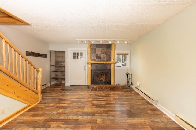 6950 Ryan Gulch Rd Unit 6950, Silverthorne, CO 80498 - unfurnished living room with baseboard heating, rail lighting, wood finished floors, stairway, and a textured ceiling