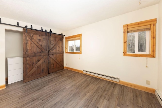 6950 Ryan Gulch Rd Unit 6950, Silverthorne, CO 80498 - empty room with a baseboard radiator, baseboards, wood finished floors, and a barn door