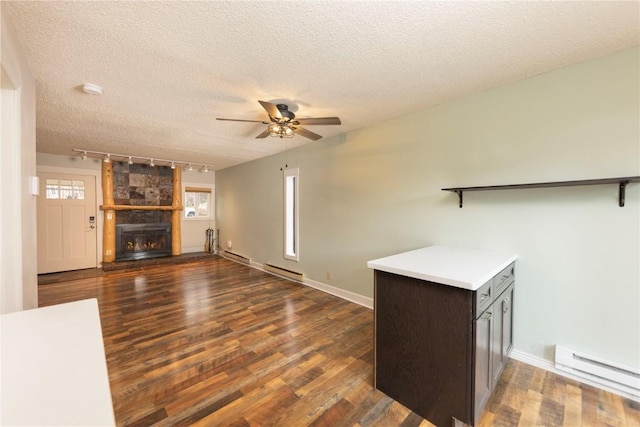 6950 Ryan Gulch Rd Unit 6950, Silverthorne, CO 80498 - unfurnished living room with track lighting, a ceiling fan, dark wood-type flooring, baseboard heating, and baseboards