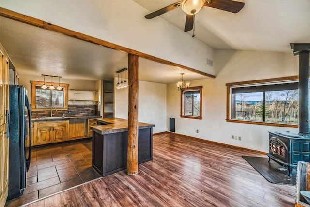 259 Falcon Rd, Como, CO 80432 - kitchen featuring a wood stove, freestanding refrigerator, a sink, healthy amount of natural light, and vaulted ceiling