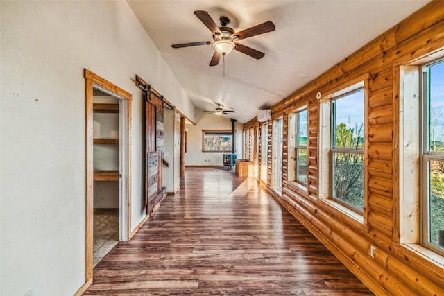 259 Falcon Rd, Como, CO 80432 - corridor with dark wood-type flooring, lofted ceiling, a barn door, and a wall unit AC