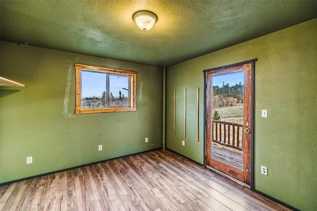 259 Falcon Rd, Como, CO 80432 - unfurnished room with wood finished floors, healthy amount of natural light, a textured wall, a textured ceiling, and baseboards