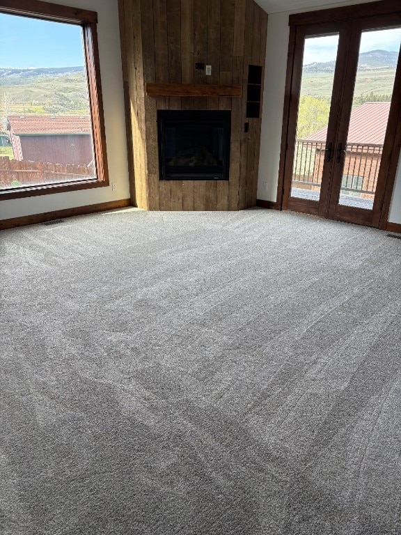 297 County Road 1012, Silverthorne, CO 80498 - unfurnished living room with carpet, french doors, a fireplace, and plenty of natural light