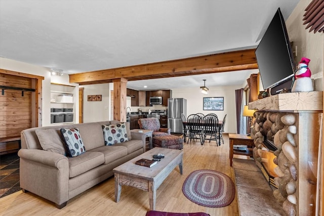living area with a stone fireplace and light wood-style floors