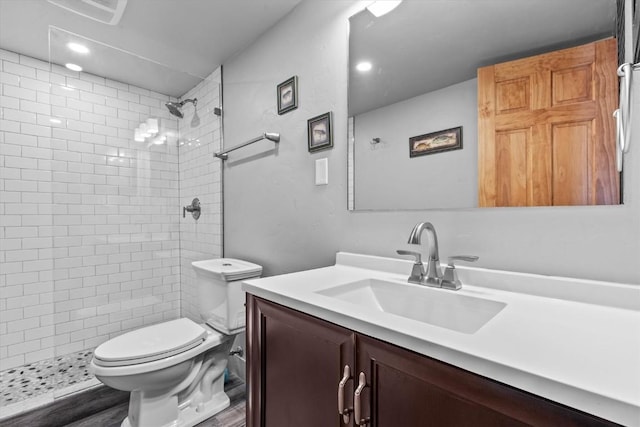 full bathroom featuring recessed lighting, vanity, toilet, and tiled shower