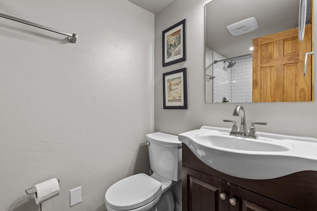 full bathroom with vanity, walk in shower, and toilet