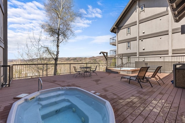exterior space featuring outdoor dining space and hot tub deck surround