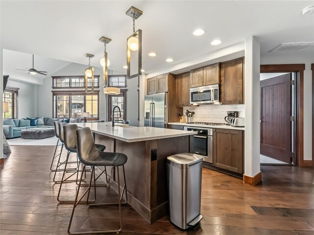 1521 Ski Hill Rd Unit 8424, Breckenridge, CO 80424 - kitchen with appliances with stainless steel finishes, dark wood-style flooring, a kitchen bar, light countertops, and a ceiling fan