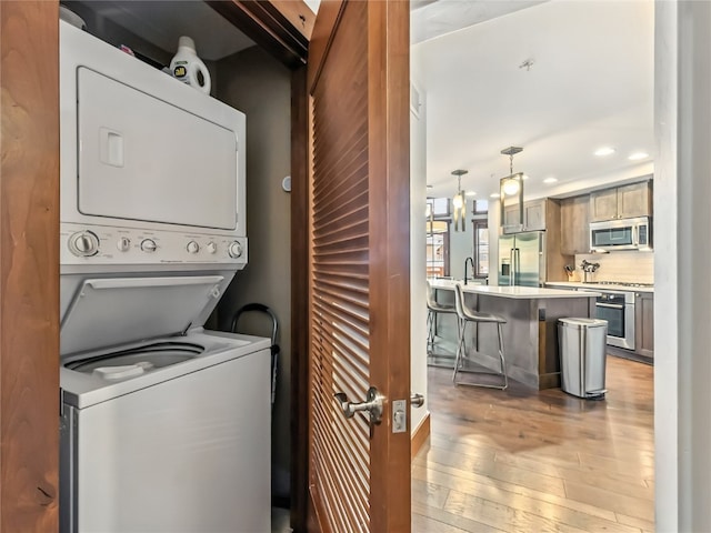1521 Ski Hill Rd Unit 8424, Breckenridge, CO 80424 - washroom featuring estacked washer and dryer, light wood-type flooring, and recessed lighting