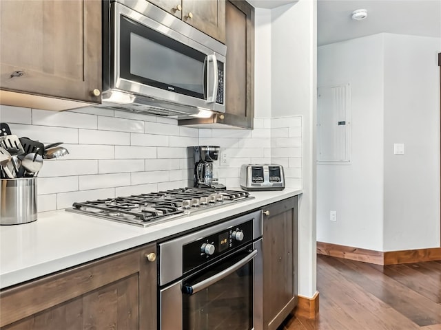 1521 Ski Hill Rd Unit 8424, Breckenridge, CO 80424 - kitchen featuring appliances with stainless steel finishes, dark wood-style floors, light countertops, tasteful backsplash, and dark brown cabinets
