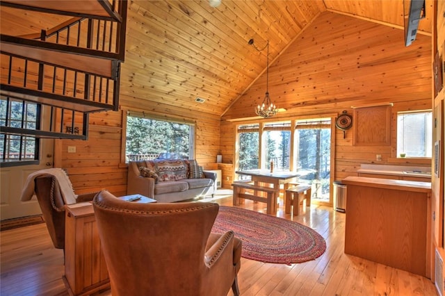 2377 Stagestop Rd, Jefferson, CO 80456 - living area featuring light wood-style floors, a notable chandelier, wood walls, wooden ceiling, and high vaulted ceiling