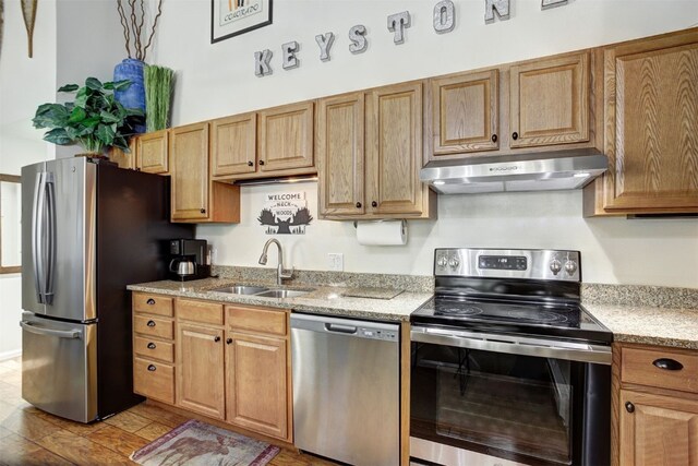1937 Soda Ridge Rd Unit 1138, Keystone, CO 80435 - kitchen featuring appliances with stainless steel finishes, under cabinet range hood, a sink, and light stone countertops