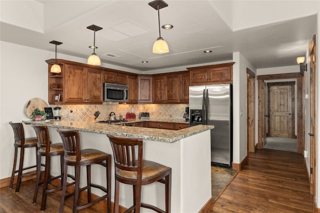 1800 Medicine Springs Dr Unit 5303, Steamboat Springs, CO 80487 - kitchen with a peninsula, appliances with stainless steel finishes, dark wood finished floors, and light stone countertops