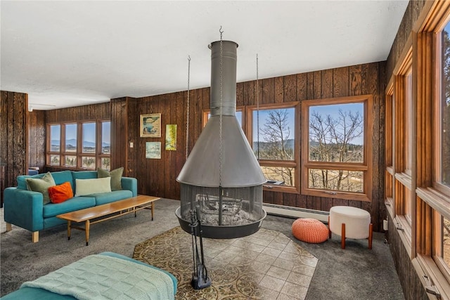 living room featuring a baseboard heating unit, carpet floors, and wood walls