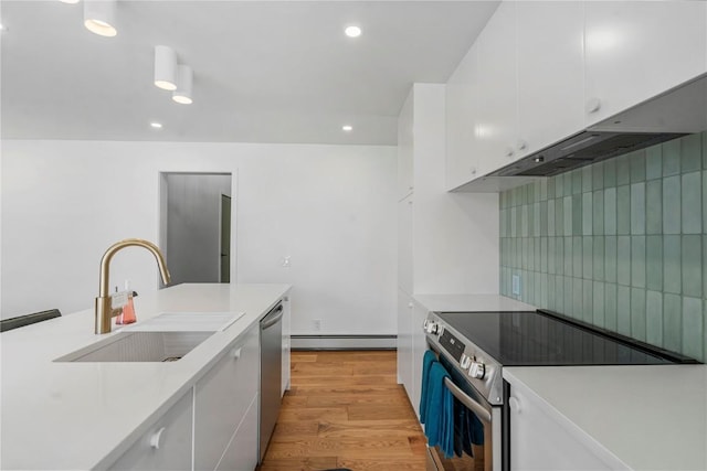 kitchen featuring baseboard heating, a sink, white cabinetry, light countertops, and appliances with stainless steel finishes
