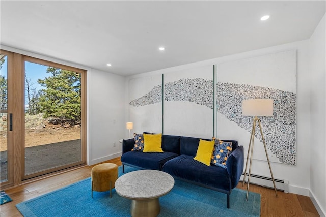 living area with recessed lighting, wood finished floors, baseboards, and baseboard heating