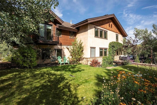 2415 Val Disere Cir, Steamboat Springs, CO 80487 - rear view of property featuring stucco siding, a lawn, and a balcony