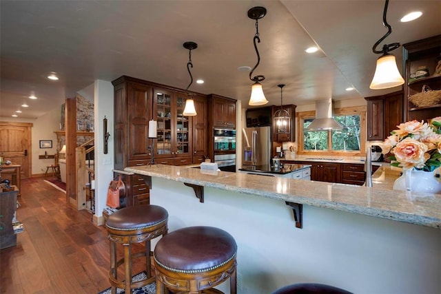2415 Val Disere Cir, Steamboat Springs, CO 80487 - kitchen with appliances with stainless steel finishes, dark wood finished floors, light stone counters, open shelves, and glass insert cabinets