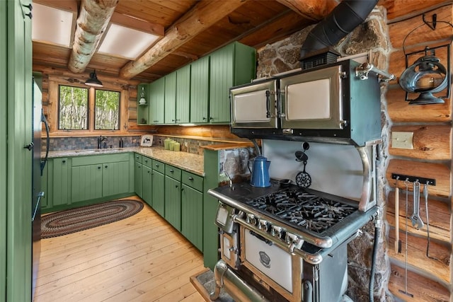 633 French Pass Cir, Jefferson, CO 80456 - kitchen with green cabinets, log walls, light wood-style floors, and a wooden ceiling with exposed beams