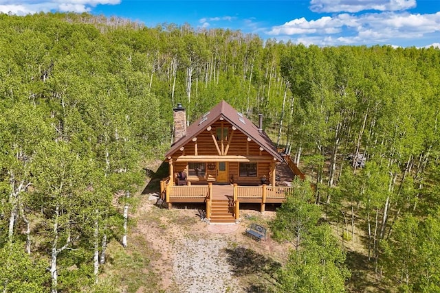 633 French Pass Cir, Jefferson, CO 80456 - view of front of home with log exterior, a chimney, a forest view, and a deck