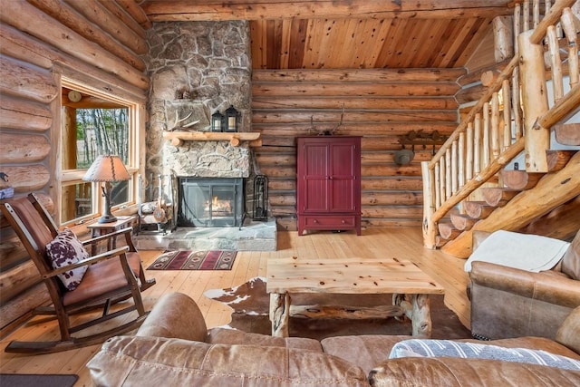 633 French Pass Cir, Jefferson, CO 80456 - living room with hardwood / wood-style floors, a wood ceiling with exposed beams, log walls, a stone fireplace, and stairway